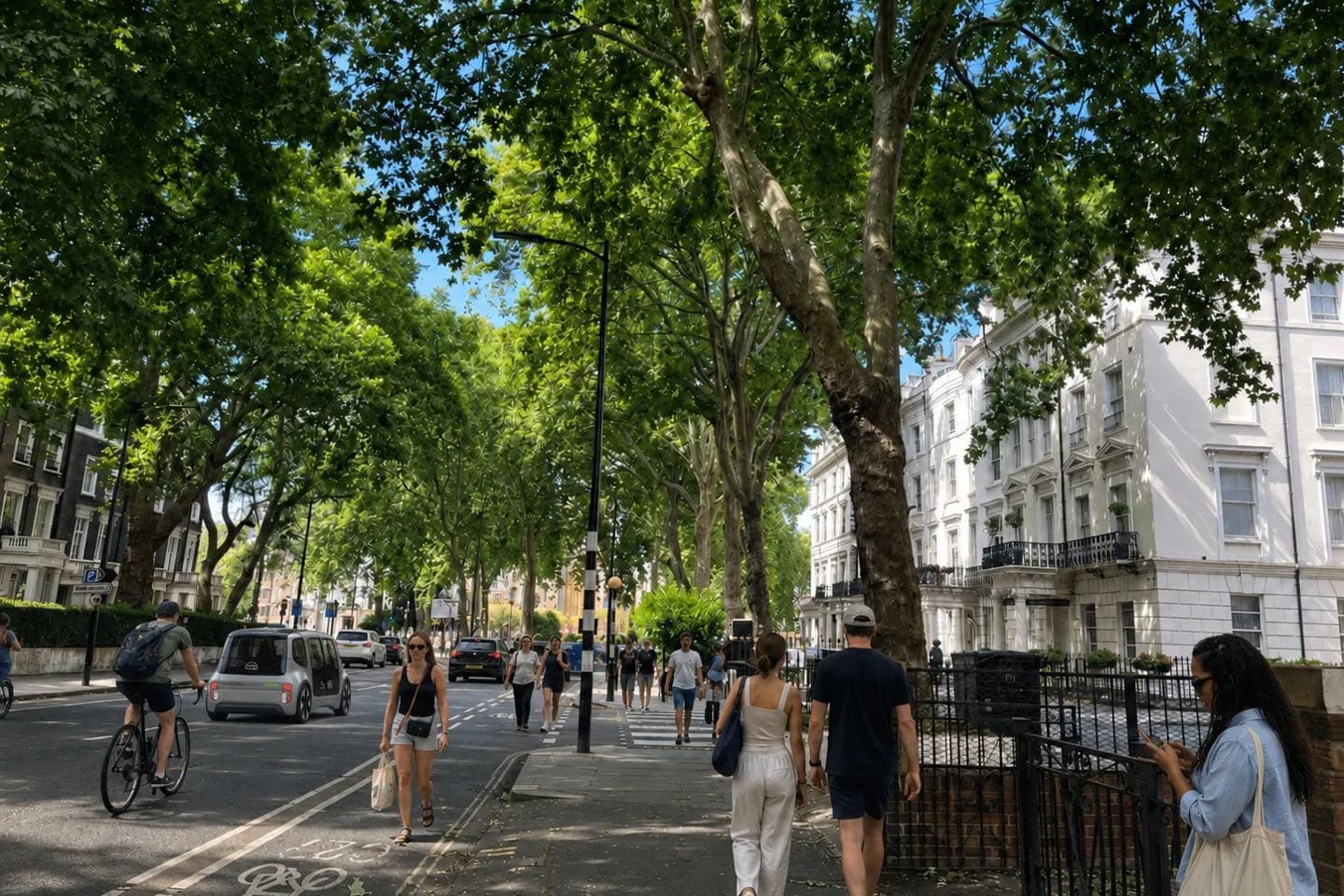 A shaded, tree-lined London street with people walking and cycling